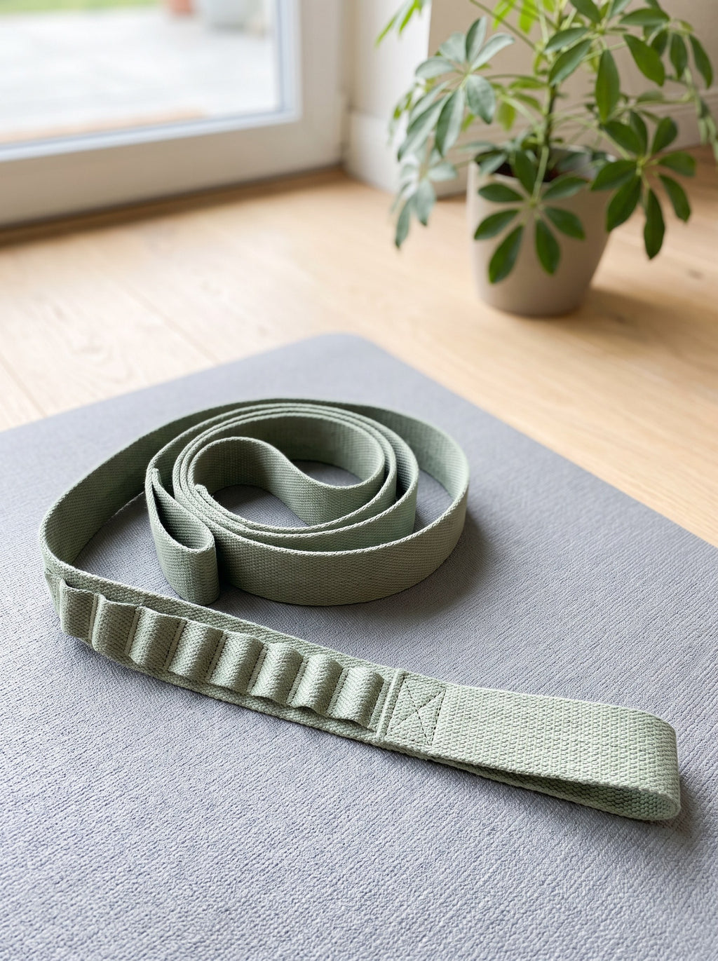 Sage 10-Loop Stretching Strap coiled on a grey yoga mat