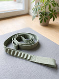 Sage 10-Loop Stretching Strap coiled on a grey yoga mat