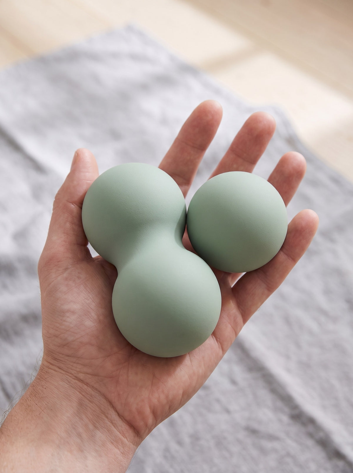 Peanut and single massage balls held in an open hand